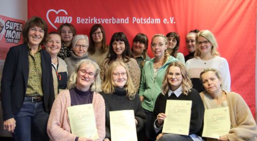 Gruppenbild: 15 Frauen, die lächeln. Vorn sitzen 4 Frauen und halten Ihre AWO Zertifikate vor sich. Die anderen Frauen stehen hinter ihnen.